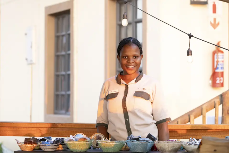 A smiling member of the team behind a table of local crafts